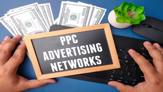 Banknotes,wireless keyboard and black board with text PPC ADVERT