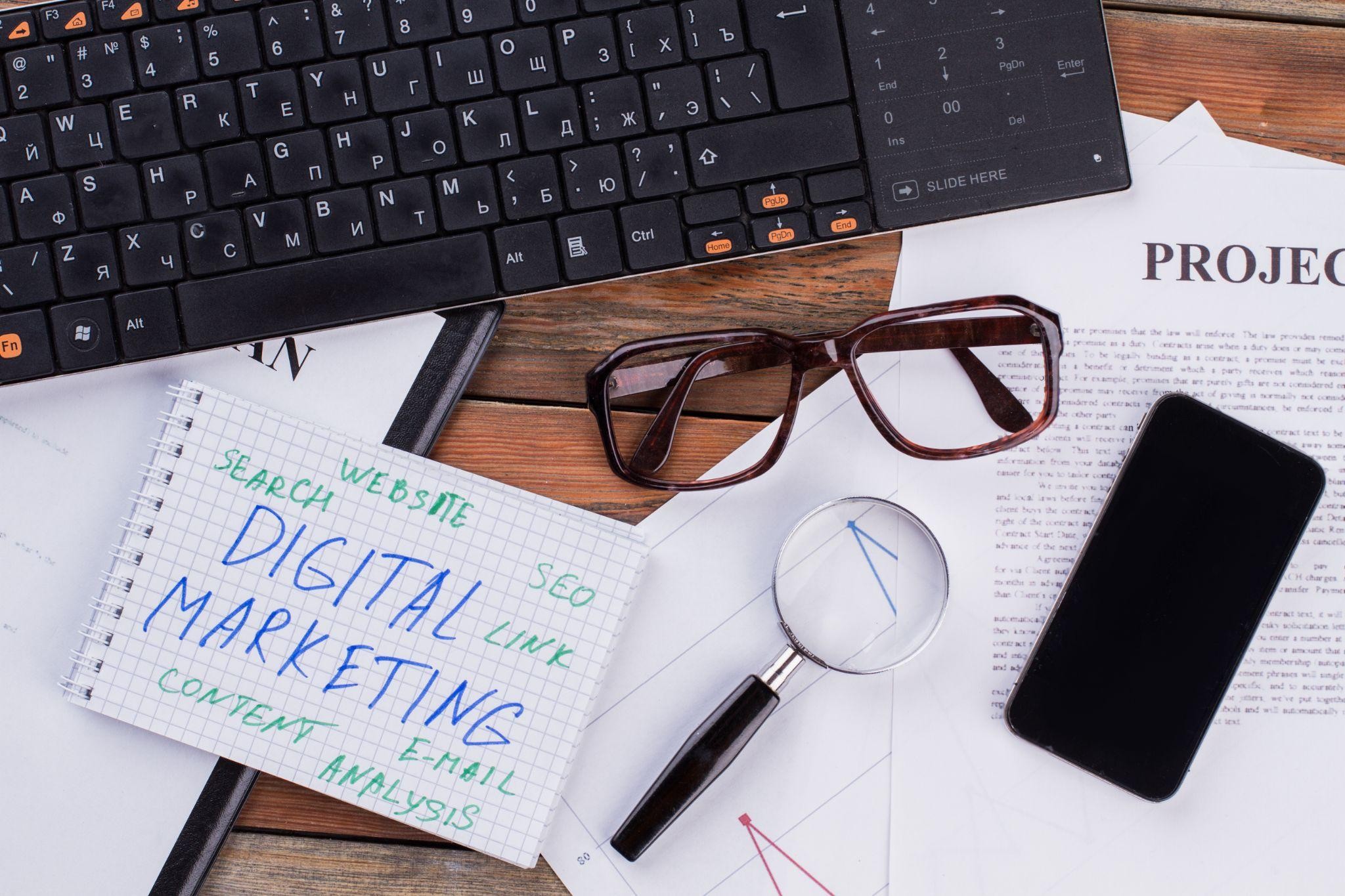 Desk setup with notepad showing digital marketing strategy keywords like SEO, content, and analysis — concept for a digital marketing agency in Dallas, TX.